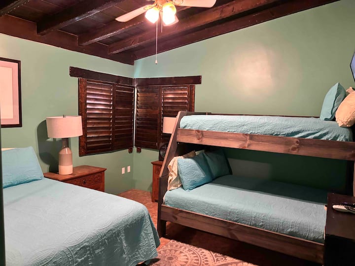 A bedroom with two bunk beds and a ceiling fan.