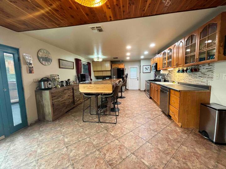 A kitchen with tile floors and wooden cabinets.