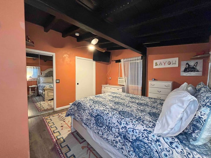 A bedroom with orange walls and blue bedding.