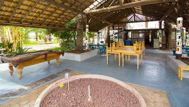 A patio with tables, chairs and a pool table.