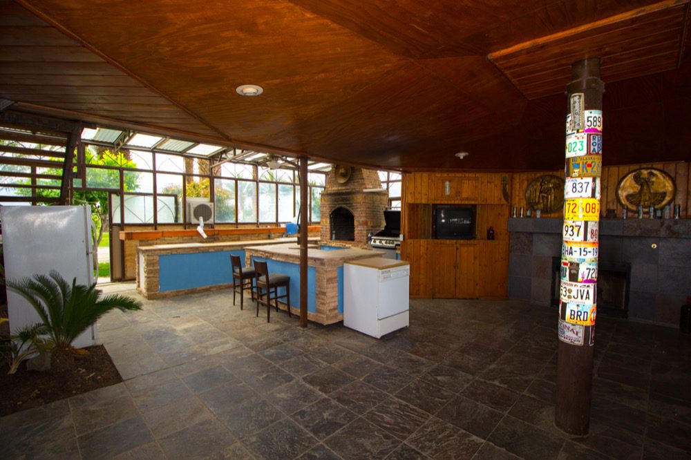 A kitchen with a fireplace and a large window.